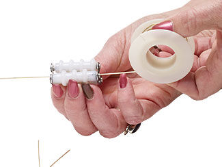 Hands using a wire straightener on a spool of wire
